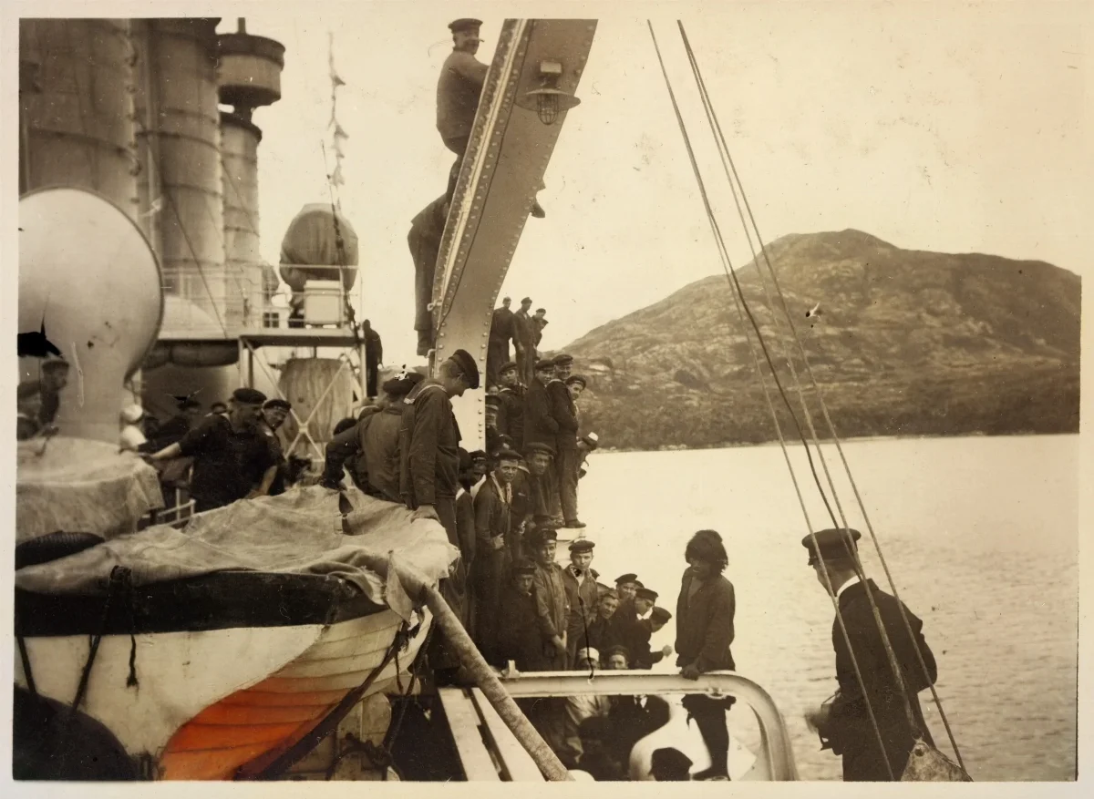 Hombre Kawésqar siendo subido al buque Fylgia, ca. 1923 — 1923 | Chile de Ayer