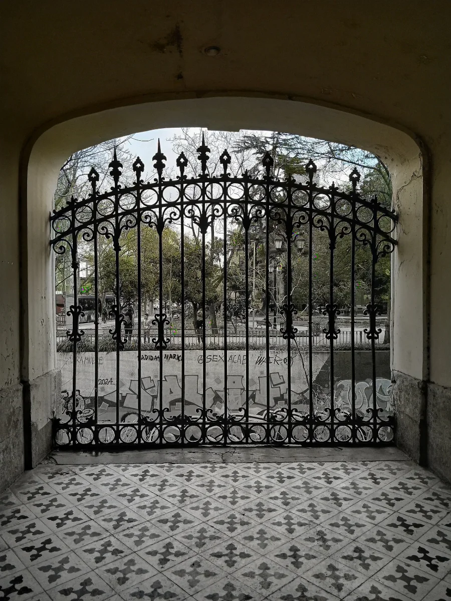 Puerta de acceso al Cerro Santa Lucía con vista a plaza arbolada — aprox. 1880–1930 | Chile de Ayer